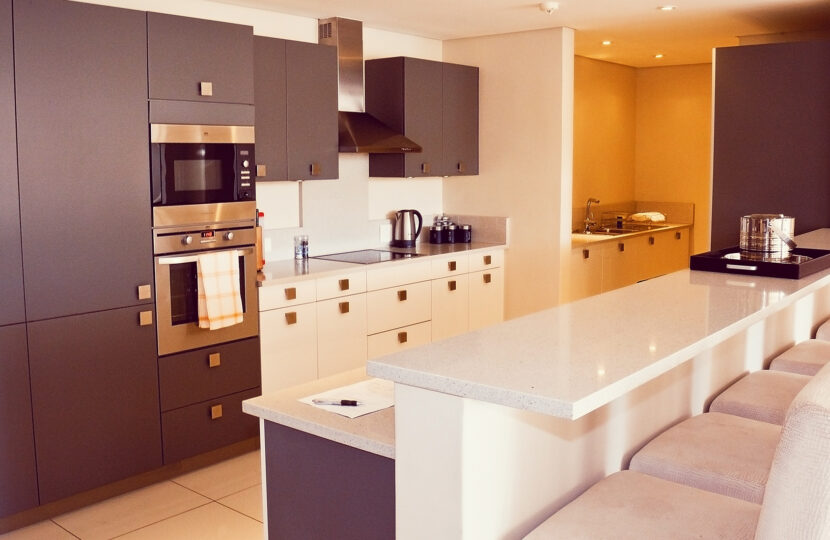 Modern kitchen with white countertops and dark cabinets.