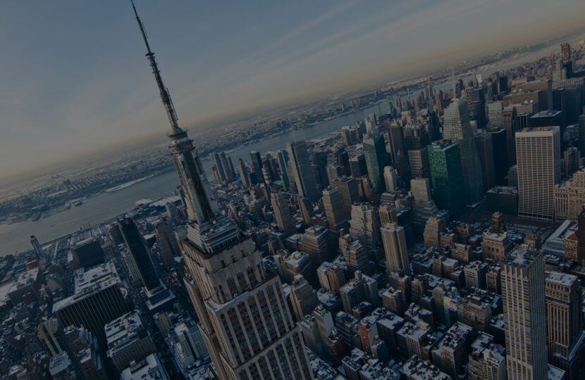 Aerial view of the Empire State Building and Manhattan skyline at sunset.