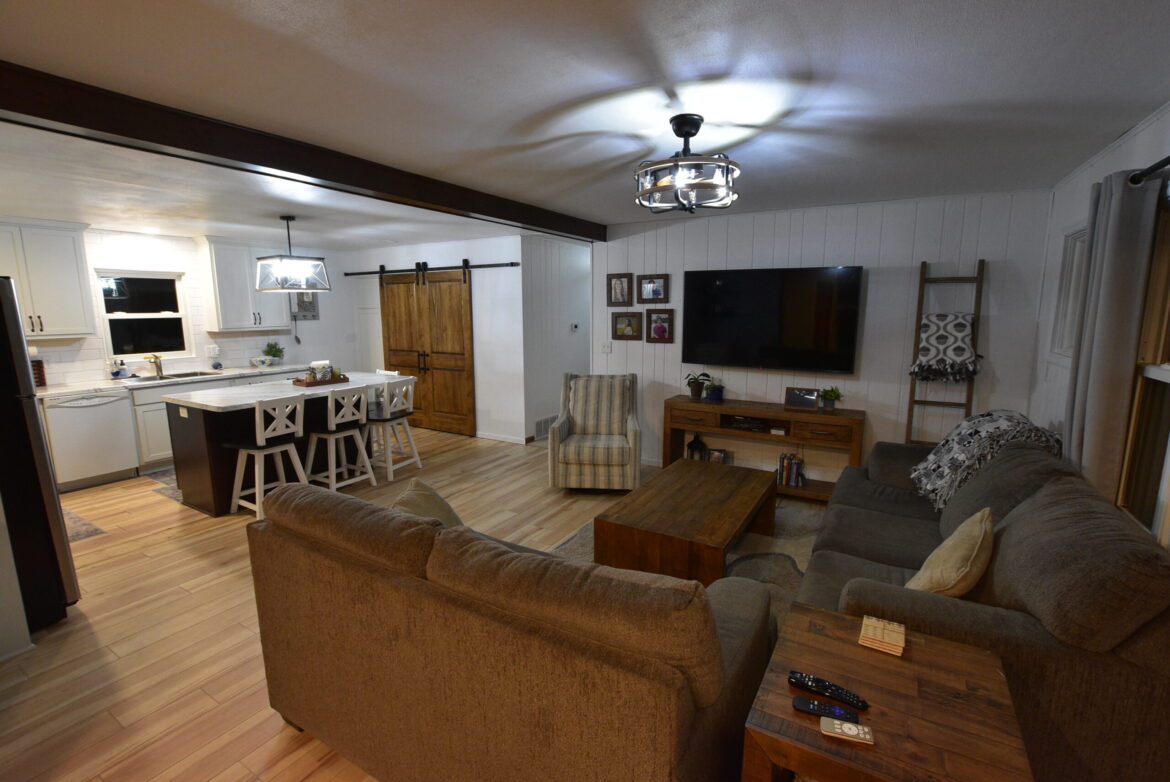 Cozy living room with brown sofas and a wall-mounted TV.